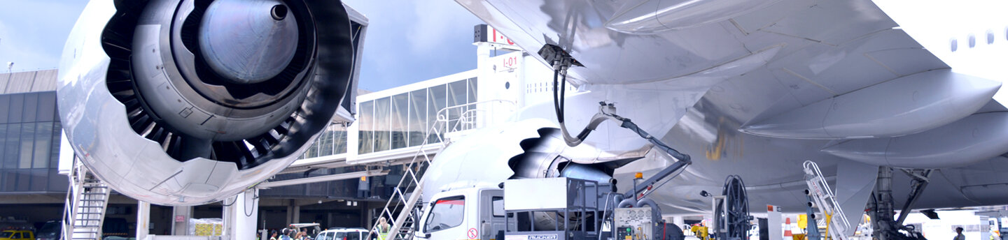 Ein Flugzeug auf einem Flughafen wird mit Treibstoff befüllt.