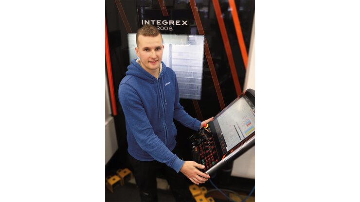 Ein Mitarbeiter steht an einer Multi-Funktions-Maschine.