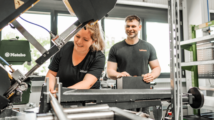 Zwei Mitarbeiter an einer Metallbandsäge